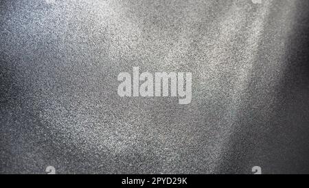 Sfondo grigio astratto con sfumatura, grana grossa. Messa a fuoco selettiva. Sfondo sfocato con puntini e bagliori. Foto Stock