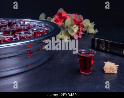 Prendendo comunione i simboli del vino e del pane su sfondo nero Foto Stock