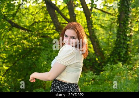 Una giovane bella donna rossa di natura verde Foto Stock