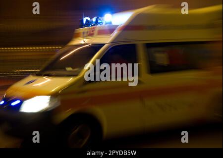 Ambulanza paramedica in movimento sfocato corse ambulanza per rispondere alla scena di un'emergenza con luce blu lampeggiante in centro. Foto Stock