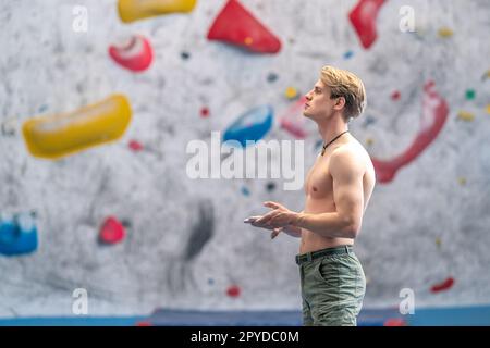 giovane uomo su un muro di arrampicata masso Foto Stock