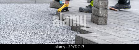 posa di asfaltatrici interbloccanti durante la costruzione di marciapiedi e strade. banner con spazio di copia Foto Stock