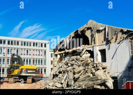 Cantiere digger giallo casa demolente per la ricostruzione Foto Stock