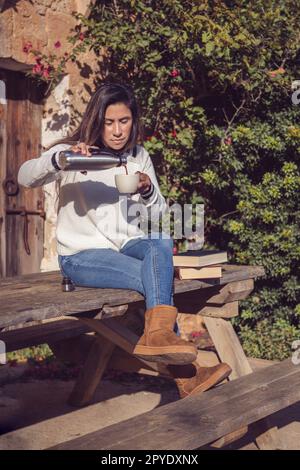 bella latina donna versa una tazza di caffè, in campagna Foto Stock