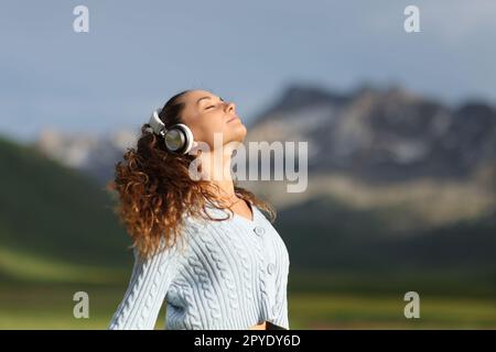 Donna che medita nella natura ascoltando l'audioguida Foto Stock