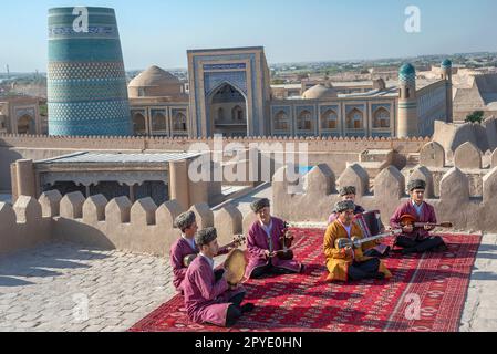 KHIVA, UZBEKISTAN - 06 SETTEMBRE 2022: Musicisti sul tetto di un vecchio edificio, Ichan-Kala. Khiva, Uzbekistan Foto Stock