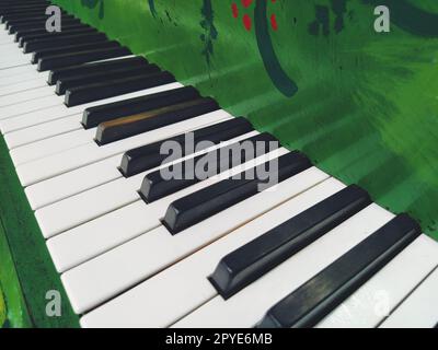 Un pianoforte o pianoforte è uno strumento musicale a percussione e tastiera. Un'ottava è un intervallo musicale in cui il rapporto delle frequenze tra i suoni è uno a due. Piano verde. Foto Stock