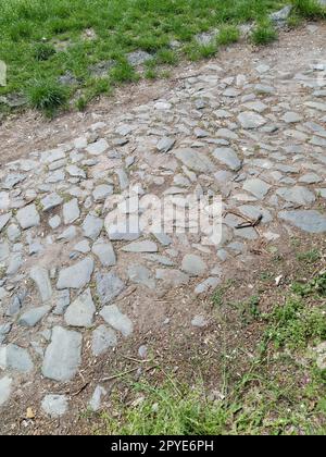 Pietre di pavimentazione - una superficie stradale dura, una sorta di pavimentazione, rivestita con barre rettangolari piatte della stessa forma e dimensione. Blocco di pietra da cui è stata costruita la superficie stradale. Petrovaradin, Novi Sad, Serbia Foto Stock