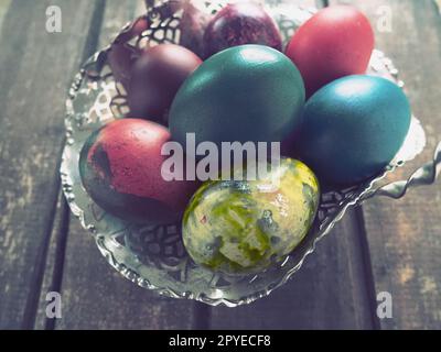 Uova di Pasqua colorate in una vecchia ciotola di caramelle metalliche su un tavolo di legno. Pasqua, la Resurrezione di Cristo, la Risurrezione luminosa di Cristo, la festa più antica e cristiana Foto Stock