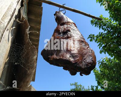 Carne. Prosciutto fatto in casa appeso a un gancio. Maiale affumicato essiccato. Cibo rustico. Ricetta popolare. Turban, Monte Fruska, Serbia. Produzione casalinga di carne. Fattoria Foto Stock