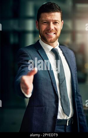 ID come costruire un nuovo rapporto di affari con voi. Ritratto corto di un bel giovane uomo d'affari che estende una stretta di mano in un ufficio. Foto Stock