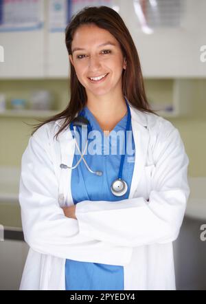 Aiutare gli altri a migliorare è quello che mi piace fare - occupazione professionale. Ritratto di una donna fiduciosa e sorridente in campo medico con le braccia incrociate. Foto Stock