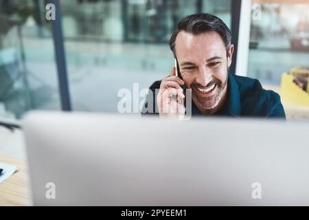 La sua sempre buona udito da voi. un uomo d'affari maturo che parla al telefono mentre guarda il suo computer. Foto Stock