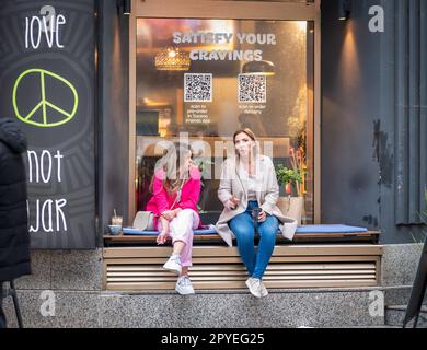 Bucarest, Romania - Aprile 2023: Scena urbana con persone sedute ai tavoli e sorseggiando un drink nel centro storico di Bucarest Foto Stock