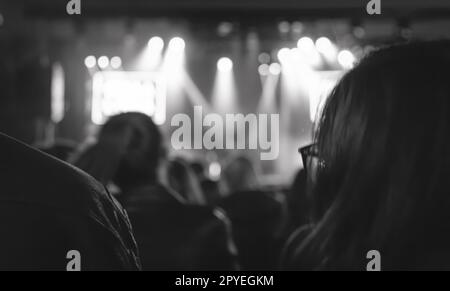 Foto in bianco e nero con silhouette di persone in un concerto musicale. Folla a festival. Foto Stock