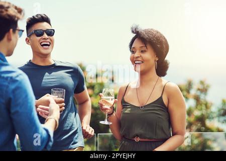 Condividiamo un legame speciale tra noi. un gruppo di amici che bevono un drink e si divertono all'aperto mentre sono in vacanza. Foto Stock