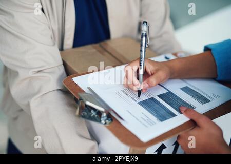 Firmare per rilasciare la consegna. Primo piano di una donna che firma per una consegna dal corriere. Foto Stock