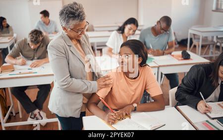 Insegnante, studente e classe per test, conoscenza e apprendimento per l'istruzione superiore. Giovane donna, donna nera o educatrice che aiuta l'allieva negli esami, a parlare o a scrivere appunti su libri o a concentrarsi Foto Stock