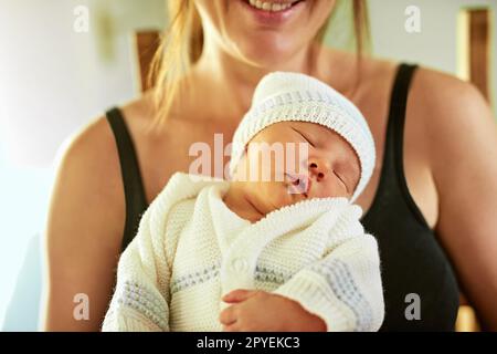 La sua ora di andare a letto per questo piccolo. un ragazzino stanco che dorme con gli occhi chiusi mentre sua madre lo tiene in mano a casa. Foto Stock