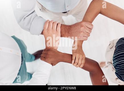 Vista dall'alto, uomini d'affari mani o che tengono i polsi in collaborazione, workshop in ufficio o solidarietà per la diversità del lavoro di squadra, la comunità o la motivazione. Uomini, donne o bracci di supporto creativi per gli obiettivi target Foto Stock