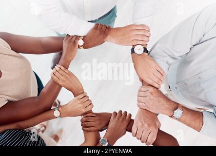 Vista dall'alto, persone d'affari mani o braccia in collaborazione, workshop in ufficio o solidarietà per la diversità del lavoro di squadra, la comunità o la motivazione. Uomini, donne o polso di supporto creativo per gli obiettivi target Foto Stock