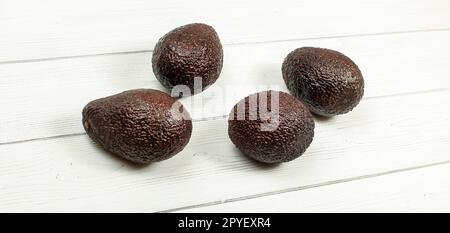 Quattro brown avocado maturo su lavagne bianche. Foto Stock