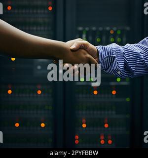 Concludere accordi nel data center. due uomini che scuotono le mani in un data center. Foto Stock