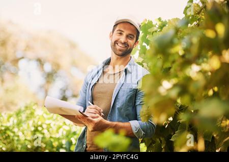 Trovo la felicità nel mio lavoro. Ritratto di un giovane contadino allegro che si posa nei campi della sua fattoria. Foto Stock