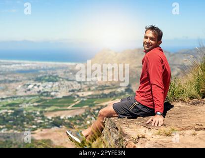 La salita era dura, ma la vista ne vale la pena. Ritratto di un giovane sportivo che ammira la vista dalla cima di una montagna. Foto Stock