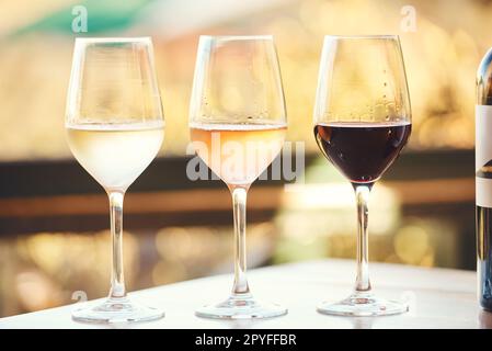 Se si desidera fare una degustazione di vini, farlo correttamente. vari vini disposti su un tavolo per una degustazione all'aperto. Foto Stock