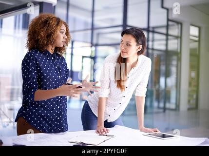 Pianificazione con precisione. due giovani architetti che lavorano su progetti in un ufficio. Foto Stock