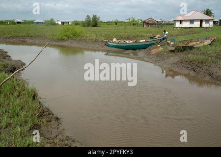 Ondo state, Nigeria - 2nd maggio 2023 - un uomo seduto su una barca circondata da acqua inquinata da petrolio ad Abereke, Comunità fluviale di Ilaje. Foto Stock