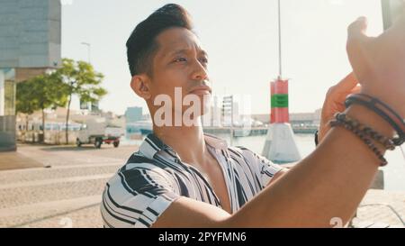 Primo piano, il giovane uomo si trova sul molo e scatta foto sul telefono cellulare Foto Stock