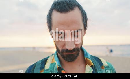 Ritratto di giovane uomo sulla spiaggia all'alba Foto Stock