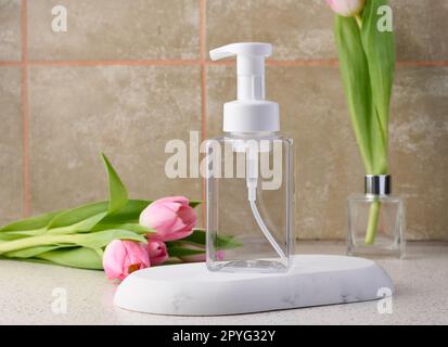 Contenitore in plastica trasparente con dispenser sul tavolo. Flacone per sapone liquido, shampoo Foto Stock