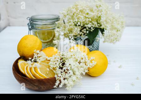 Ingredienti per limonata fatta in casa da sciroppo fresco da fiori di sambuco con limoni. Cocktail analcolico estivo rinfrescante. Foto Stock