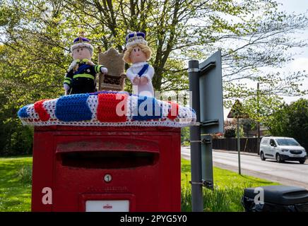 Un omaggio a maglia a re Carlo e regina Camilla su una casella postale inglese suburbana per la loro incoronazione il 6th maggio 2023. Foto Stock