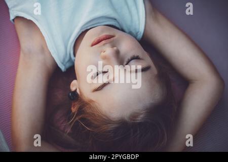 Buon bambino meditando sul tappetino yoga Foto Stock