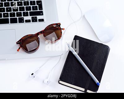 Pronti per una giornata produttiva. un computer portatile, occhiali, mouse e notebook su un tavolo. Foto Stock