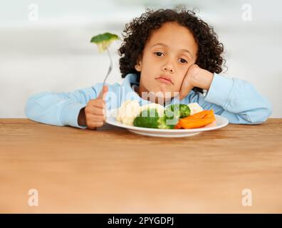 Non mi piacciono i veggies. Un ragazzino molto insoddisfatto di dover mangiare verdure. Foto Stock