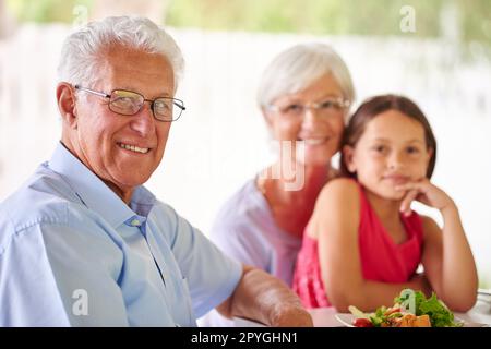 Amiamo quando viene a visitare. Ritratto di una bambina che pranzava con i nonni. Foto Stock