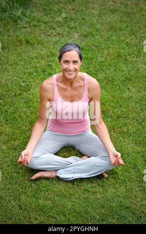 Appena lasciante andare... una donna matura attraente che pratica yoga nella posizione del loto. Foto Stock