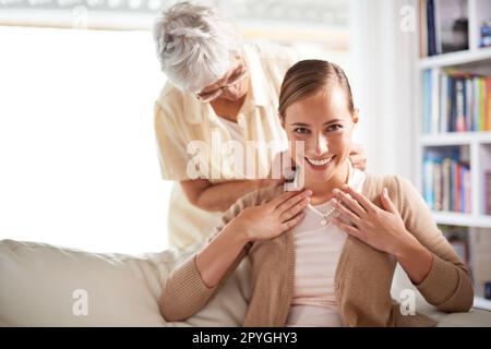 Tutte le donne della nostra famiglia hanno portato questo. Una donna anziana che dà a sua figlia una collana di perle. Foto Stock