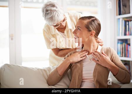 Tutte le donne della nostra famiglia hanno portato questo. Una donna anziana che dà a sua figlia una collana di perle. Foto Stock