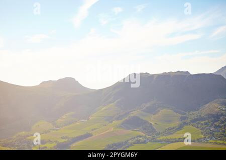 Coltivare contro le montagne. Ripresa aerea di terreni coltivati che corrono fino alle montagne. Foto Stock