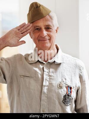 Veterano orgoglioso. Un veterano di guerra anziano che guarda la telecamera indossando la sua divisa. Foto Stock