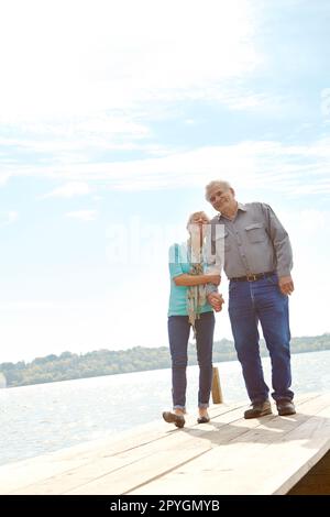 Lo adora. Immagine a tutta lunghezza di una coppia matura che si snoda lungo il molo. Foto Stock