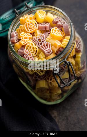 Pasta di varie forme spaventose. Pasta di halloween cruda in vaso. Foto Stock