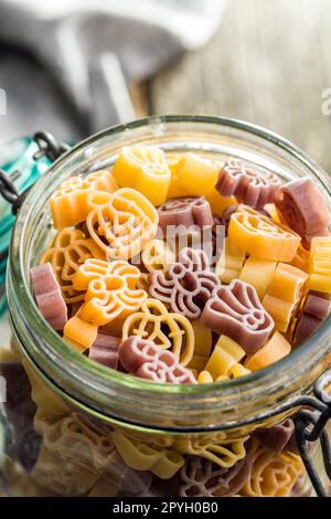 Pasta di varie forme spaventose. Pasta di halloween cruda in vaso. Foto Stock