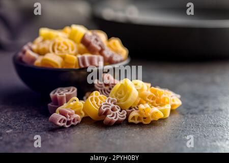 Pasta di varie forme spaventose. Pasta di halloween cruda in ciotola. Foto Stock